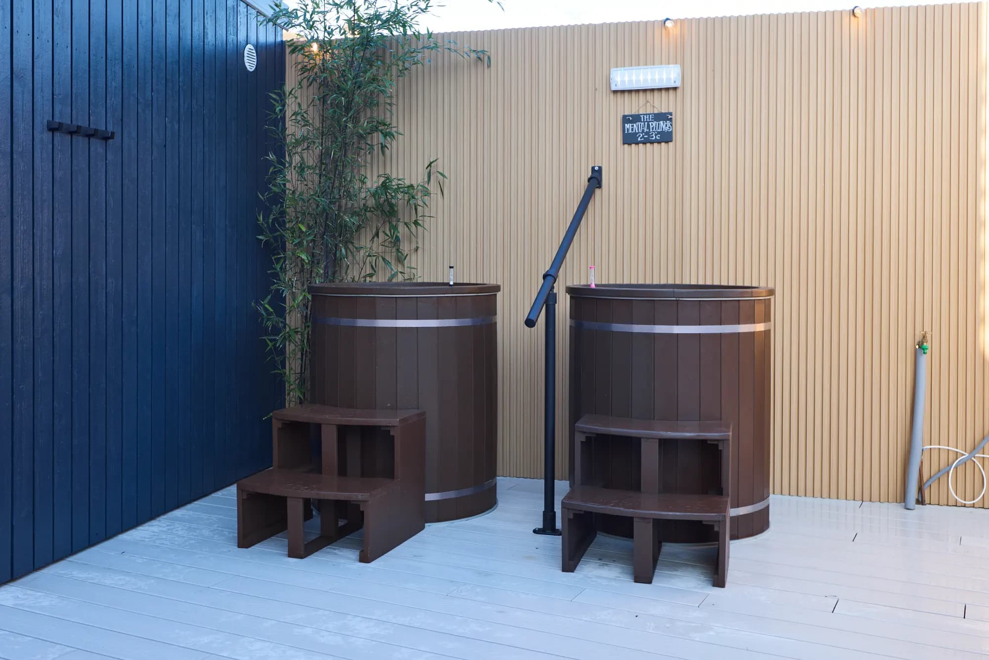Twin cedar cold plunge tubs under a timber pergola