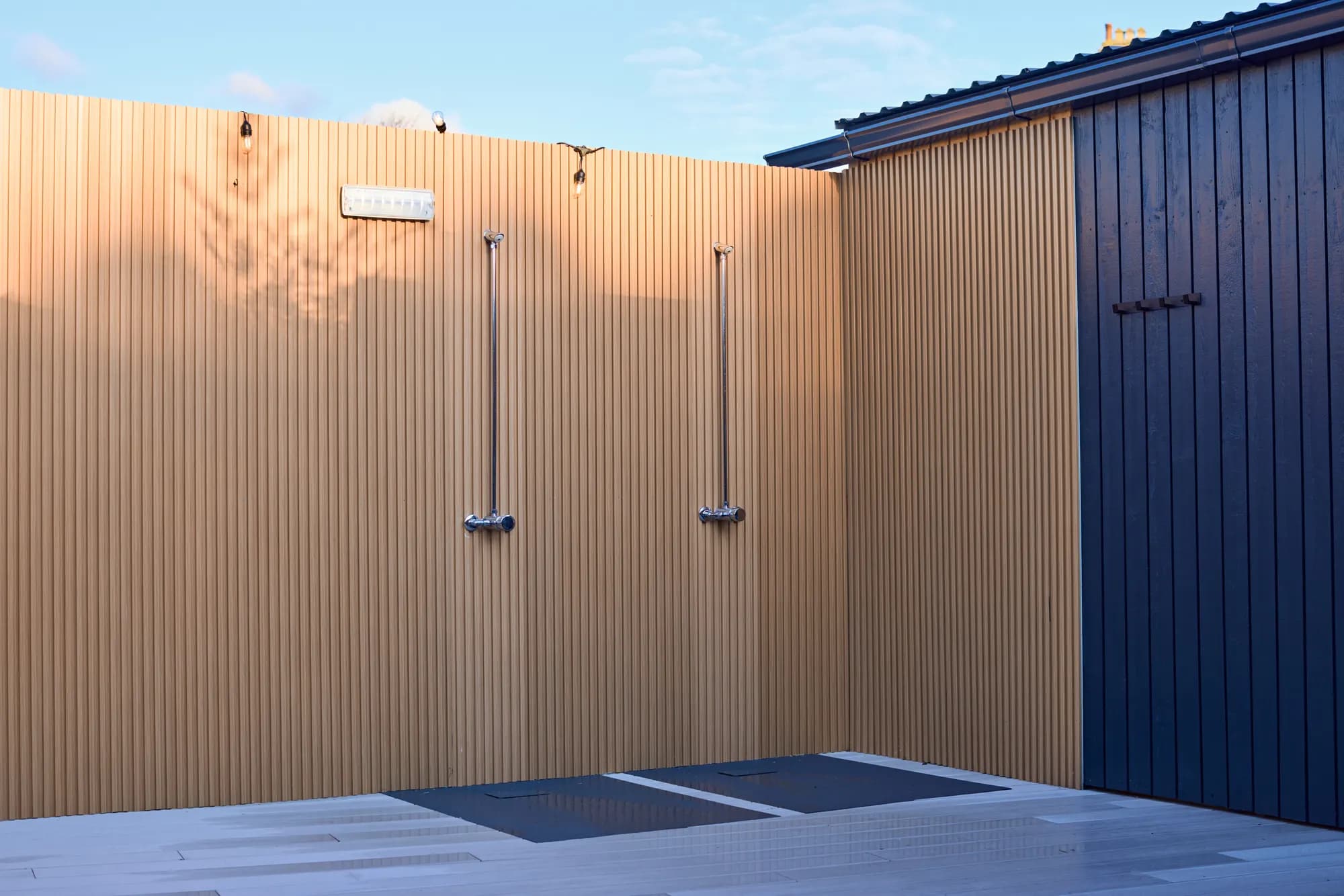 Open-air hot showers against timber cladding