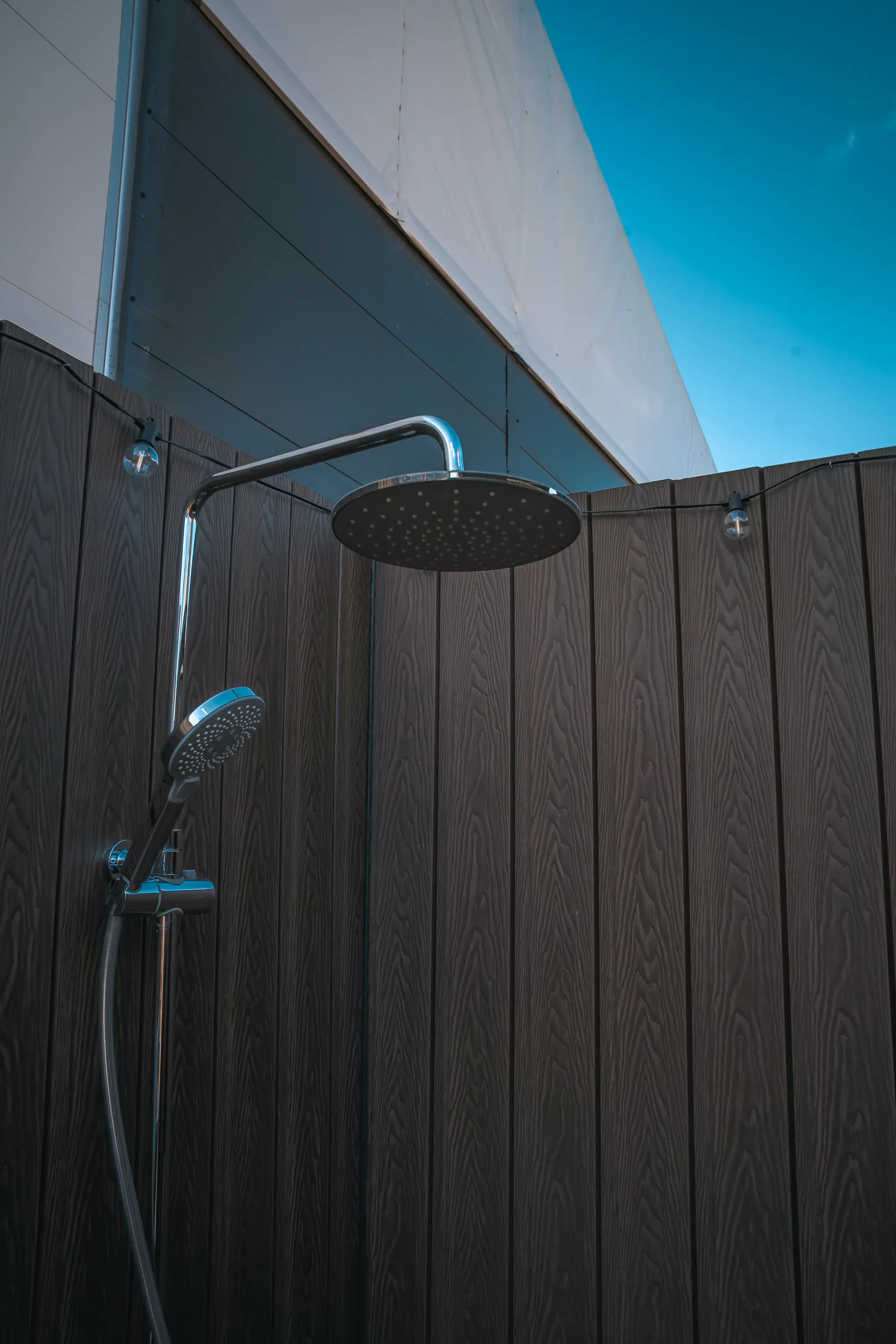 Black rainfall shower against dark cladding